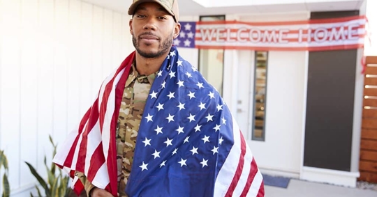 military man with an American flag over his shoulders