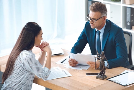 lawyer and client looking at each other while discussing divorce in office