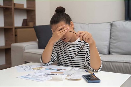woman sitting by a table looking stressed