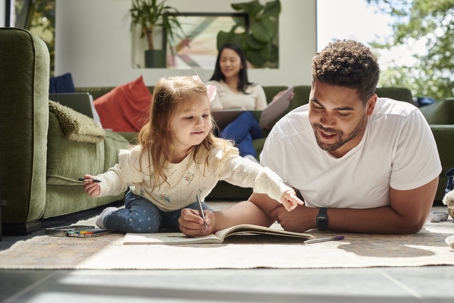 father and daughter spending time together with mother in the background
