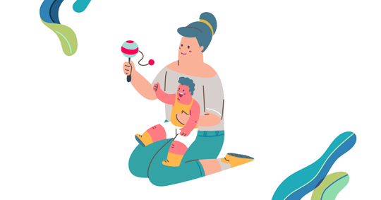 A woman is sitting and holding a baby, who is playing with a rattle.