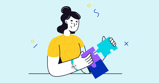 A person wearing a yellow shirt is putting colorful puzzle pieces together.