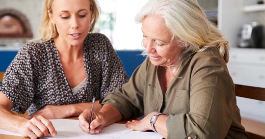 Two women signing a paper