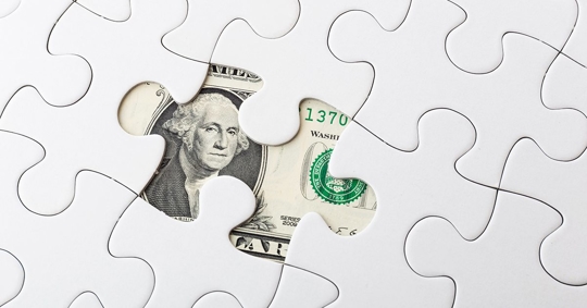 Puzzle pieces with a dollar bill