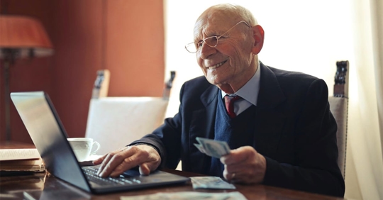 an old man using his laptop