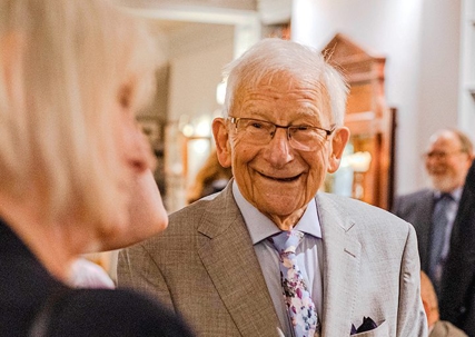An old man smiling at an old woman