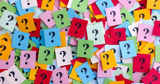 Many small, colorful squares with black question marks printed on them.