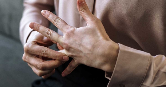 A person is putting a ring on a finger.