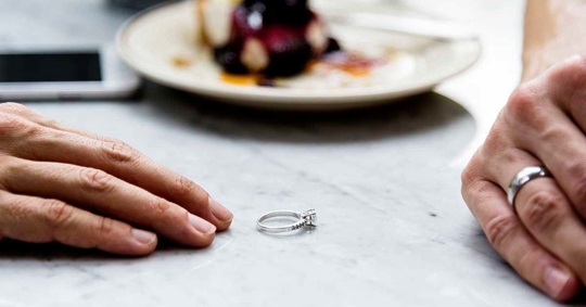 A silver ring sits on a marble table.
