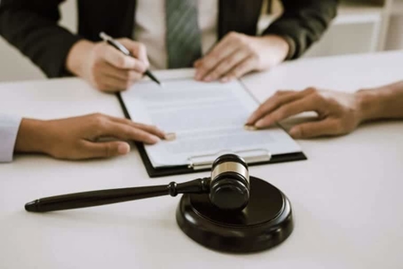 People are signing documents at a table.